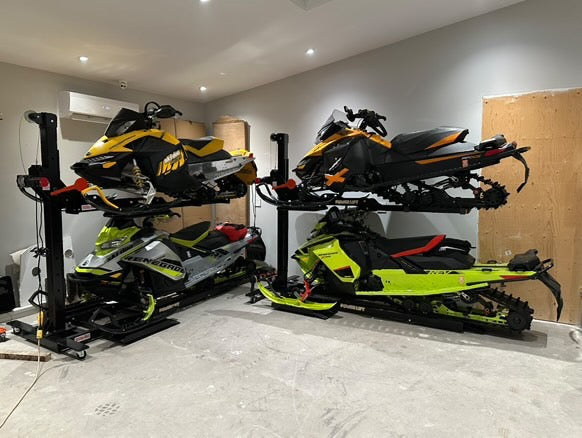 Four snowmobiles on a two hoists saving floor space.